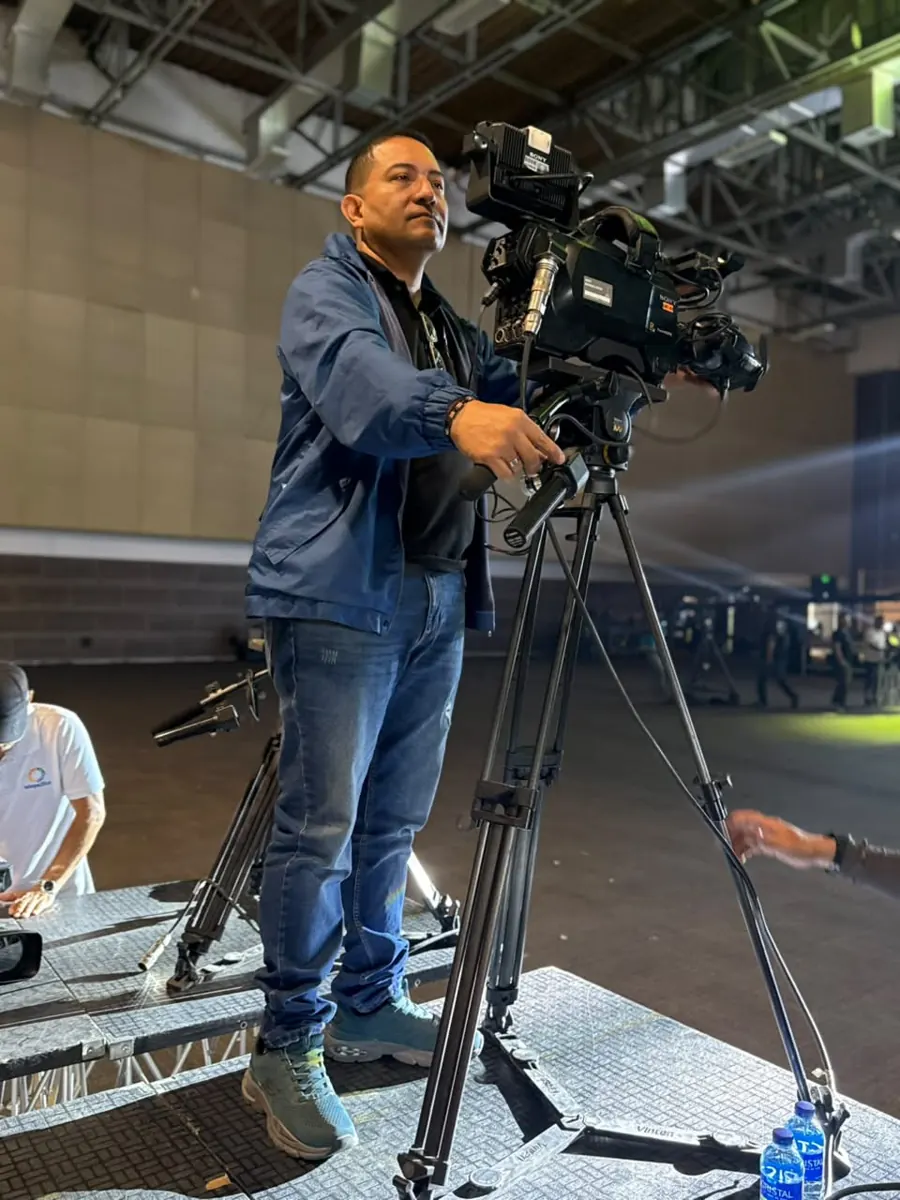 Camarógrafo sobre una tarima con cámara de estudio